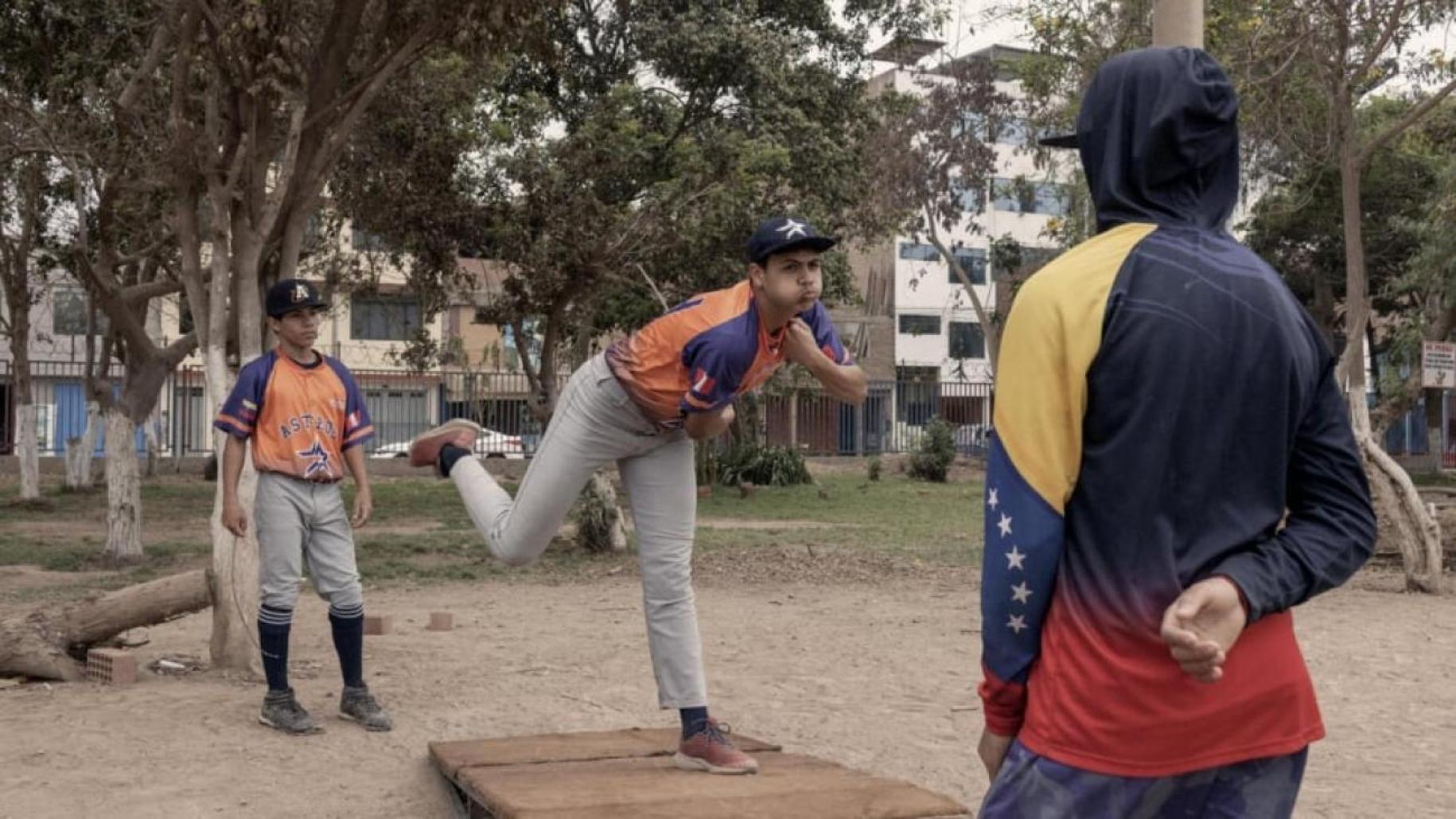 two young boys play baseball outside