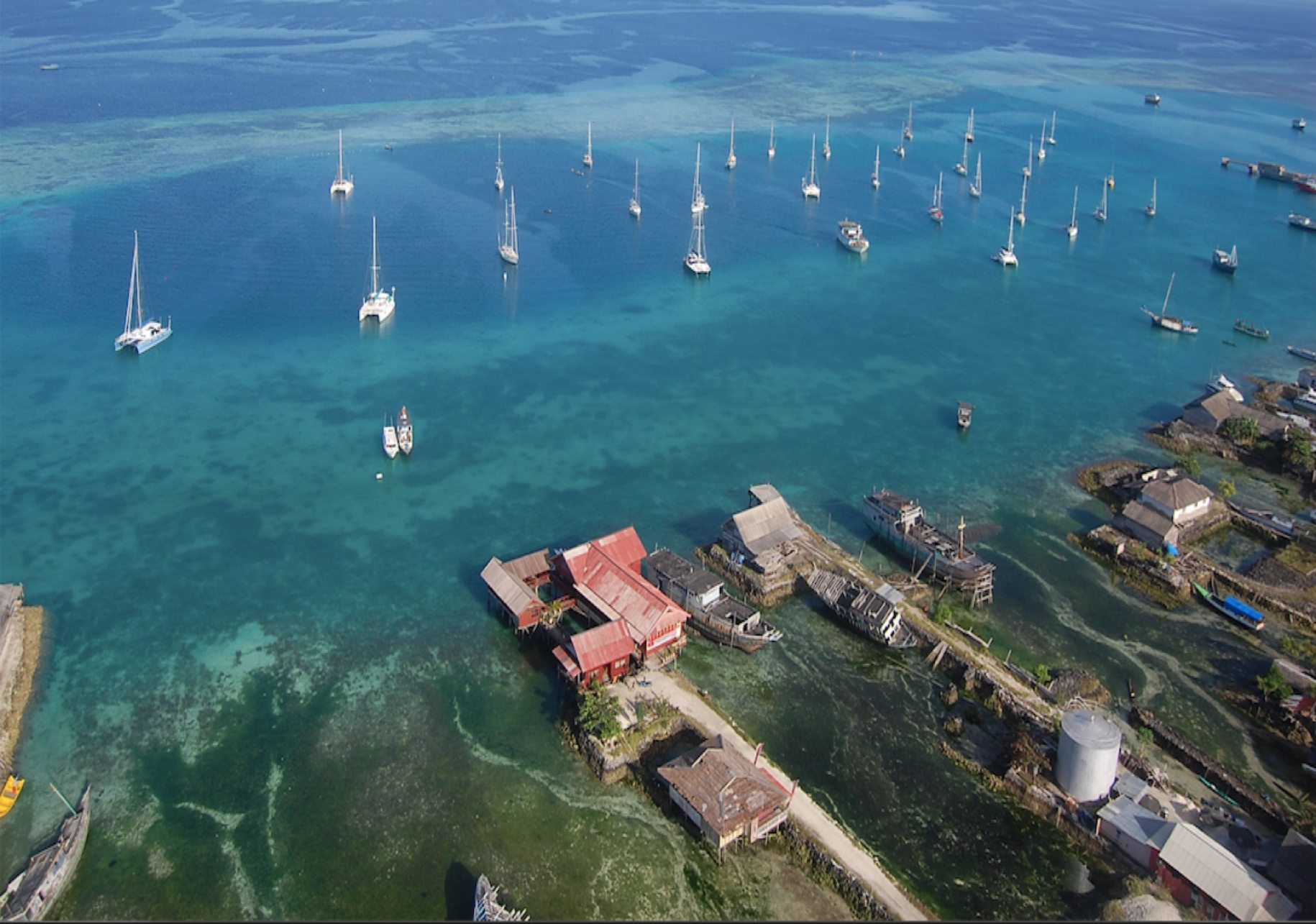 An aerial shot of boats on blue waters in Indonesia