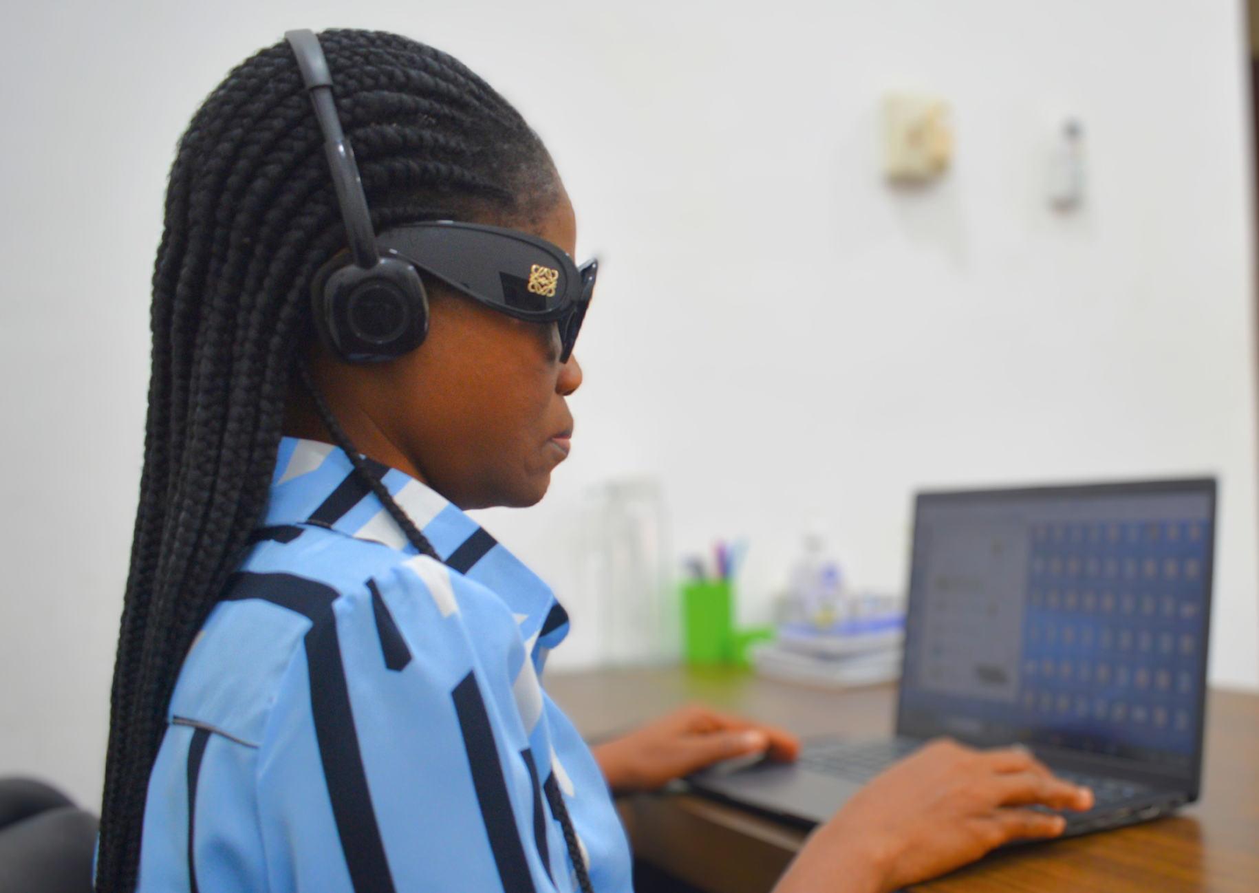 Alimata Abdul is sitting at a desk using her computer. 